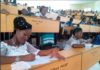 Two Benue State University students write exams in wedding gowns
